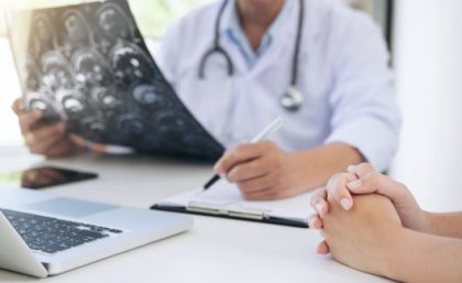 A doctor looks over notes with a pen in hand